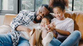 Family on sofa laughing